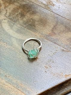 a green ring sitting on top of a wooden table