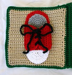 a crocheted christmas stocking on top of a pillow