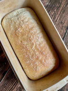 a loaf of bread sitting in a pan on top of a wooden table