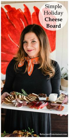 a woman standing in front of a table with food on it and the words simple holiday cheese board above her