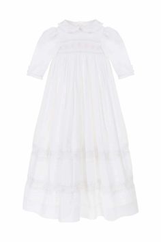 A future family heirloom, this traditional Christening or ceremony gown is the most exquisite gown in the Annafie catalogue yet! Truly fit for a little princess or prince, it features delicate hand smocking and embroidery both across the chest and on the skirt. The ruffled peter pan collar and elegant sleeves create a romantic silhouette which is completed by the traditional long skirt that will drape over your arms as you carry your baby. Made from 100% fine, breathable and extremely luxurious Fitted Wedding Dress With Smocked Cuffs, Fitted Smock Wedding Dress, Elegant Smocked Dress With Smocked Cuffs For Baptism, Elegant Baptism Dress With Smocked Back, Elegant Smocked Ruffle Dress For Baptism, Elegant Dress With Smocked Back For Baptism, Elegant Smocked Dresses For Baptism, Elegant Smock Dresses For Baptism, Elegant Fitted Smocked Dress With Lace Trim