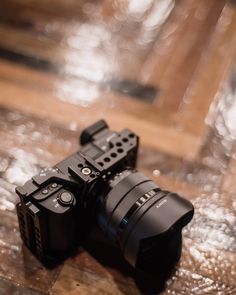 two cameras sitting on top of a wooden table