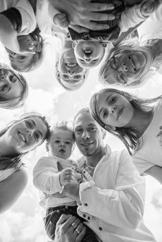 a group of people standing around each other in the middle of a circle, looking up at the camera