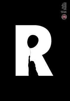 a black and white photo of a person holding a balloon in the shape of the letter r