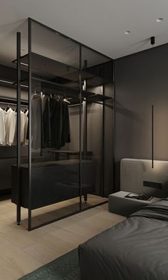 a bedroom with a bed, closet and clothes on hangers next to it's doors