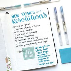 a notebook with new year's resolutions written on it next to pens and markers