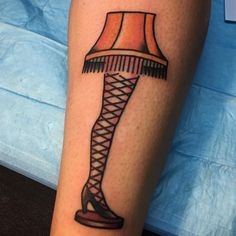 a woman's leg with a lamp tattoo on it