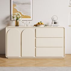 the sideboard is white and has flowers on it, along with other decor items