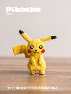 a crocheted pikachu doll sitting on top of a wooden table