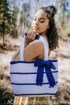 a woman wearing a blue and white crochet bag