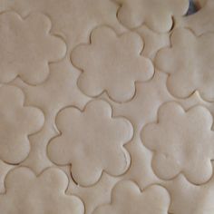 the cookies are shaped like flowers on top of each other, and ready to be baked