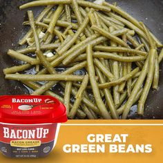 green beans are being cooked in a frying pan with baconup on the side