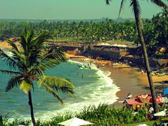 the beach is lined with palm trees and umbrellas as people walk on the sand