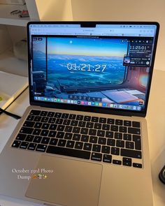 an open laptop computer sitting on top of a white desk next to a mouse and keyboard