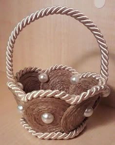 a basket made out of twine and pearls