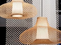 two woven lamps hanging from the ceiling in front of wallpapered walls and windows