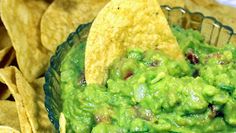 a bowl filled with guacamole and tortilla chips