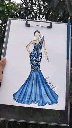 a drawing of a woman in a blue dress on a piece of paper with a marker