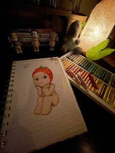 a drawing of a teddy bear with a red hat on it's head sitting next to some books