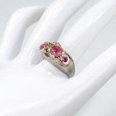 Natural Tourmaline Sterling Silver Ring Sz 8.25 Total Carat Weight (TCW): 38.45 Main Stone Shape: Cabochon Main Stone: Tourmaline Main Stone Size: 7x5 mm M Main Stone Creation: Natural Plating: Black Rhodium & Rose Gold Ring Size: 8.25 Secondary Stone: Topaz, Rhodolite Pink Sapphire Three-stone Jewelry, Pink Three-stone Sapphire Jewelry, Pink Sapphire Three Stone Jewelry, Pink Sterling Silver Gemstones For Anniversary, Pink Tourmaline Sapphire Ring, Pink Multi-stone Round Sapphire Ring, Pink Multi-stone Sapphire Promise Ring, Silver Sapphire Ring With Pink Sapphire Accent Stones, Pink Sapphire Three Stone Jewelry For Anniversary