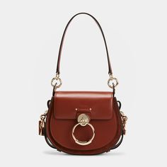 Chloe "Tess" crossbody bag in calf leather Detachable top handle  Detachable, adjustable crossbody strap Flap top with oversized ring accent  Approx. 6.7"H x 7.9"W x 2.8"D Made in Italy Chloe Tess Day Bag, Designer Crossbody Saddle Bag With Gold-tone Hardware, Chloe Small Tess Bag, Chloe Tess, Chloe Crossbody Bag, Denim Shoulder Bags, Leather Saddle Bags, Black Leather Handbags, Small Crossbody Bag