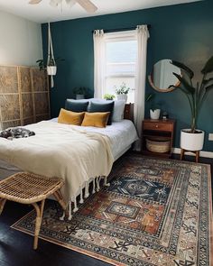 a bedroom with blue walls and a large rug on the floor next to a bed