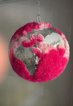 a pink and white ball hanging from a chain