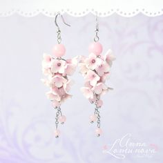 a pair of earrings with pink flowers hanging from them