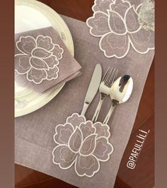 an image of a table setting with silverware and flowers on the placemats