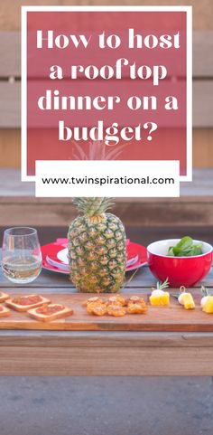 a pineapple sitting on top of a wooden table next to plates and bowls filled with food