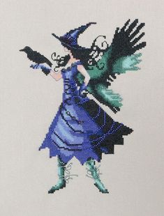 a cross - stitch picture of a woman dressed as a witch