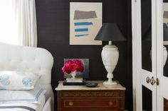 a white chair sitting next to a lamp on top of a table in a room