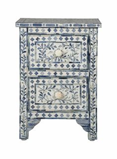 a blue and white cabinet with two drawers on one side, an ornate design on the other