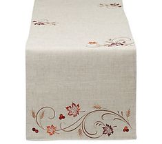 a table runner with flowers and leaves on the top, along with a white background