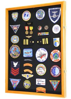 a shadow box with many different patches and insignias on the front, along with other badges