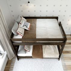 a wooden bed frame with pillows and blankets on it