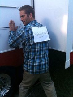 a man standing in front of a trailer holding his hand up to the side of it