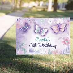 a sign with butterflies on it sitting in the grass