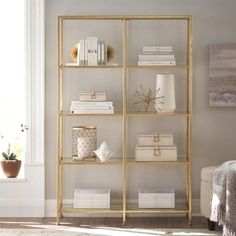 a book shelf with books and other items on it in a room next to a window