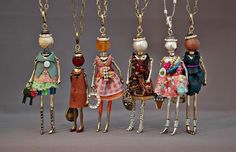 five different sized dolls are hanging from chains