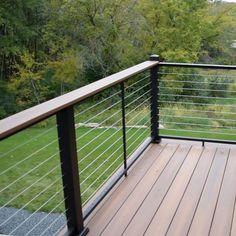 a wooden deck with metal railing and handrails