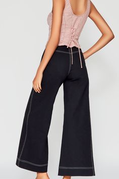 A forever favorite silhouette, our Erika pants are responsibly handcrafted in NYC from non-stretch denim. Featuring a high rise fit with functional pockets and a flattering wide leg. The front closure is adorned with antique brass jean buttons adding texture and shine and the detailing of the contrast topstitching creates a standout mapping of the seams. Pair with the Leslie bustier top to complete the look. Model is wearing size XS. Model Height: 5'10" Dark Wash Wide Leg Flare Jeans With Seam Detailing, Denim Cropped Leg Pants With Seam Detailing, Wide Leg Bottoms With Seam Detailing For Spring, Dark Wash Cropped Leg Flare Jeans With Contrast Stitching, Dark Wash Cropped Wide Leg Pants With Five Pockets, Dark Wash Mid-rise Bottoms With Contrast Stitching, Dark Wash Flare Jeans With Contrast Stitching, Cropped Leg, Mid-rise Dark Wash Bottoms With Contrast Stitching, Chic Dark Wash Wide Leg Jeans