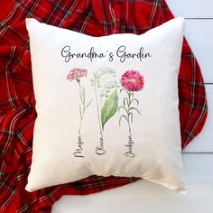 a white pillow with pink flowers on it and the words grandma's garden written in cursive writing