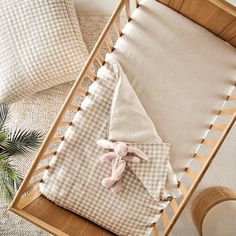 a baby's crib with two pillows and a stuffed animal on the bed