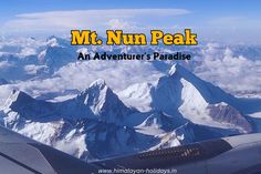 an airplane flying over mountains with the words mt nun peak