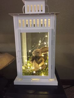 a stuffed animal in a white lantern with fairy lights on the top and bottom part