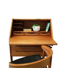 a wooden desk with a book shelf, chair and vase sitting on top of it