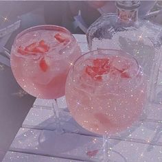 two glasses filled with pink liquid sitting on top of a table