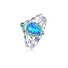 Indulge in the timeless beauty of our Lab-Grown 9 x 6 mm Teardrop Blue Opal Cabochon Ring, a treasure designed to evoke emotions and create lasting memories. Surrounded with vibrant Nano Emerald accent stones of varied sizes, this stunning teardrop shape holds deep symbolism, representing emotions and new beginnings.    Crafted with enduring 925 sterling silver, this ring showcases rhodium plating, enhancing its brilliance and protecting it from tarnish. The total weight of the ring is 4 grams, Blue Teardrop Promise Ring, Teardrop Sapphire Promise Ring, Silver Teardrop Ring With Gemstone Accents, Spiritual Turquoise Opal Gemstone Ring, Blue Multi-stone Opal Ring In Fine Jewelry Style, Unique Turquoise Multi-stone Opal Ring, Peacock Blue Opal Ring, Ring And Band Set, Sterling Silver Halo Ring