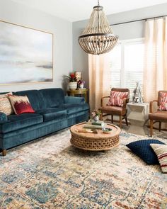 a living room filled with furniture and a chandelier hanging over the top of it